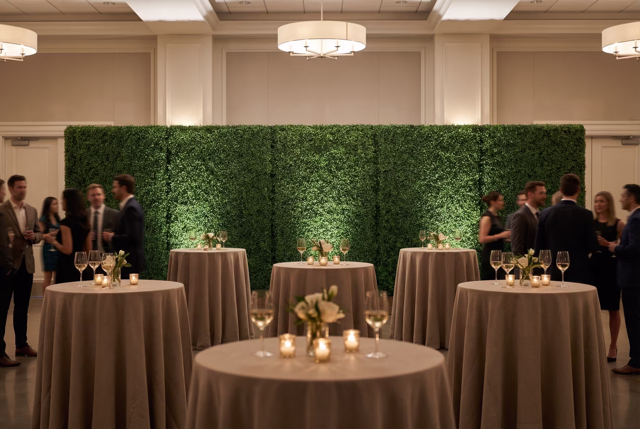 Boxwood hedge wall backdrop at a corporate gala event with ambient lighting